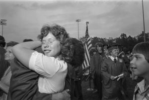 image of women and girl hugging at a graduation event.