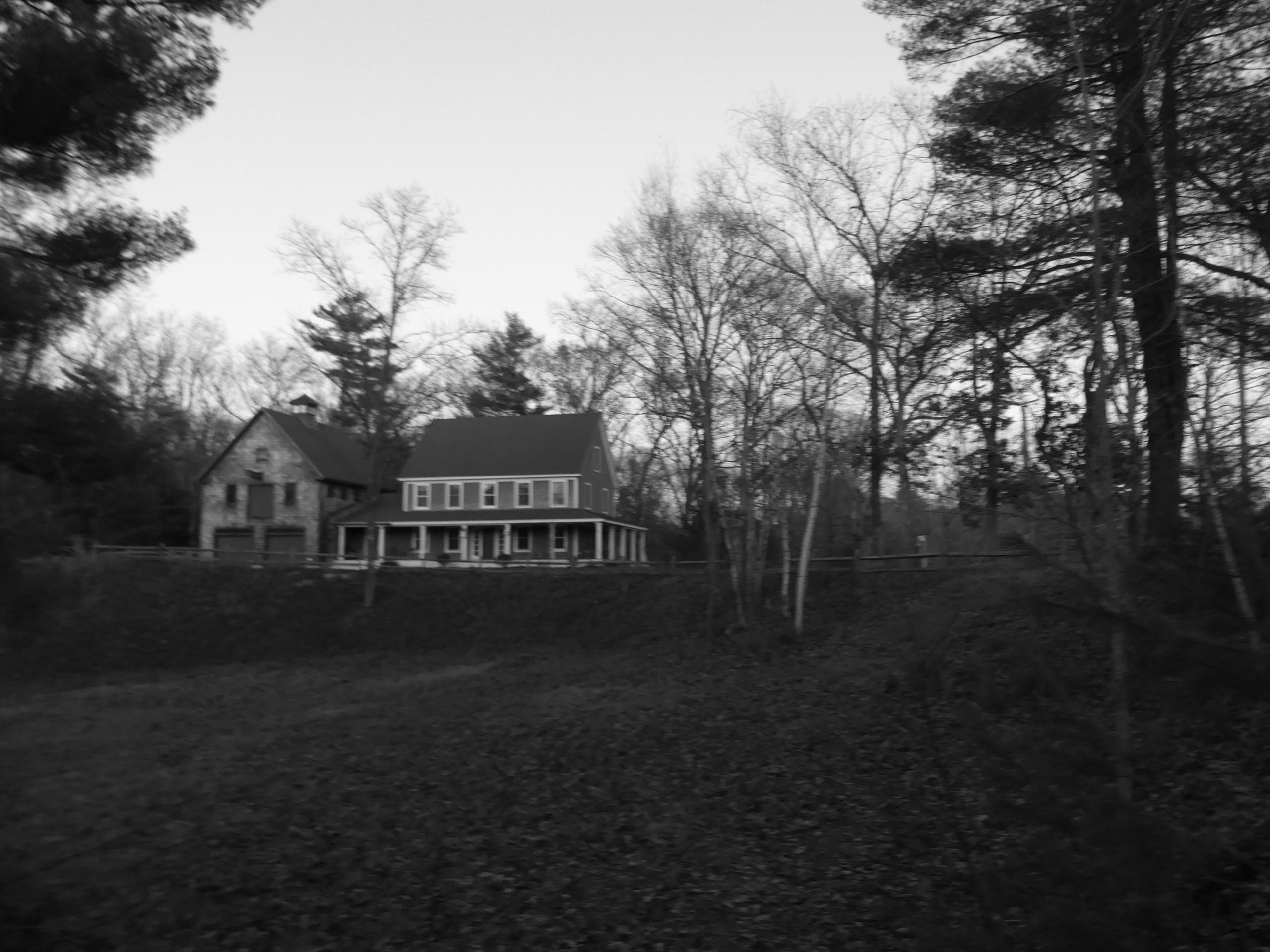 A farmhouse sits atop a hill.